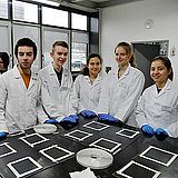 Studierende in Laborkitteln im Labor
